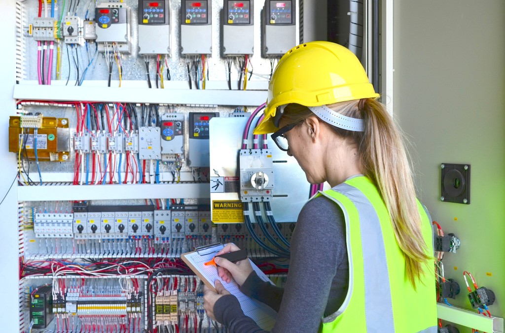 How do electricians ensure compliance with electrical codes and regulations?